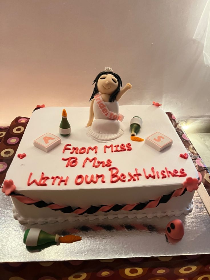 a birthday cake with a doll on top that says from miss to mrs with our best wishes