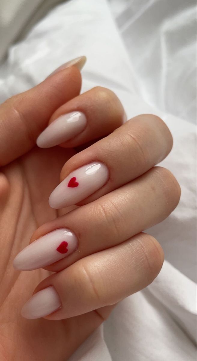 Off White Valentines Nails, Milky Nails With Heart Design, Valentine White Nails, Minimalist Nails Milky White, White Almond Nails With Red Heart, Oval Nails With Hearts, Red And White Acrylic Nails Almond, White Nails For Valentines Day, Valentines Day Nails Milky White