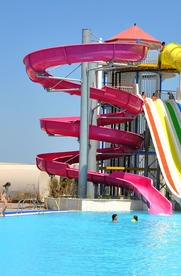 people are swimming in the pool with water slides