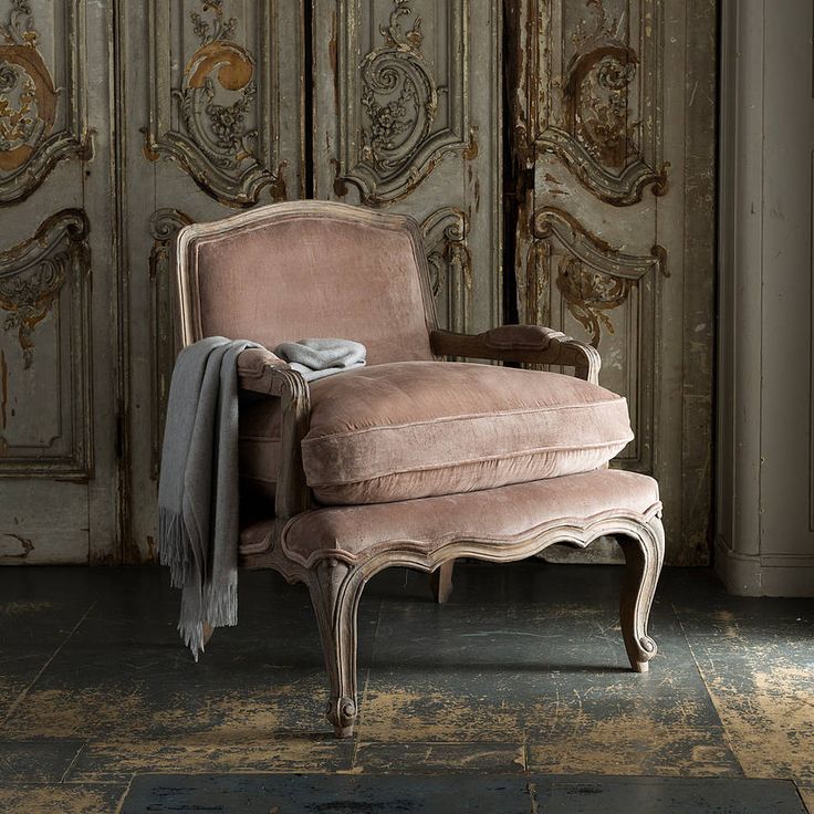 an old chair sitting in front of a wooden door