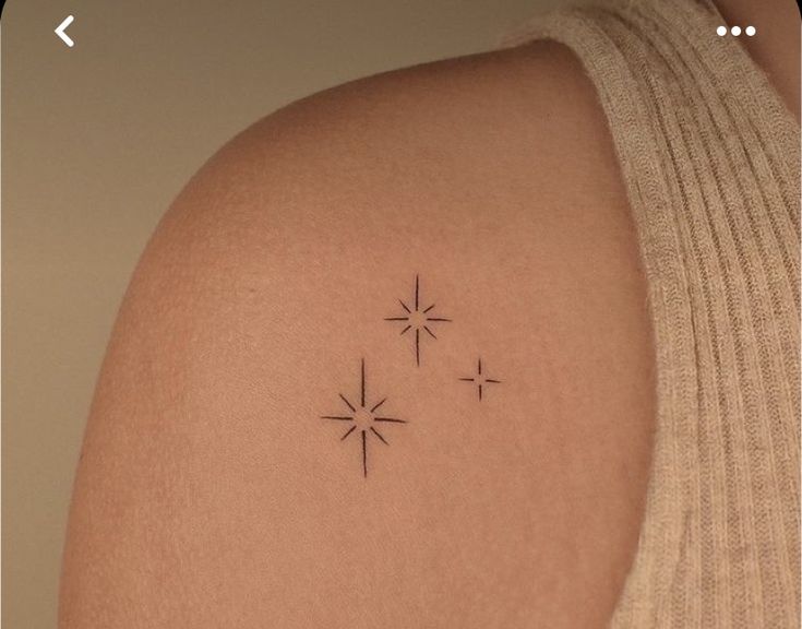 a woman's arm with three small stars on the back of her left shoulder