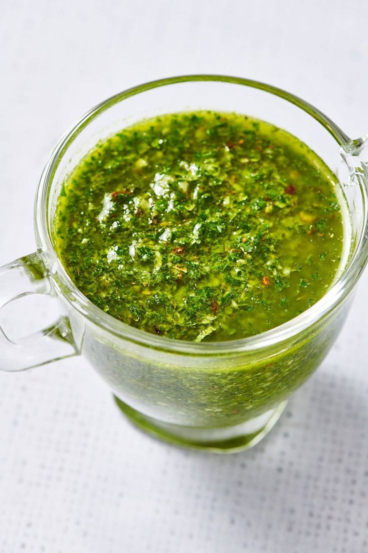 a cup filled with green liquid on top of a table