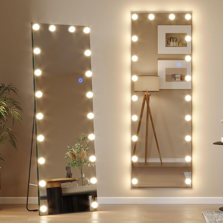 a large mirror with lights on it in a living room next to a table and chair