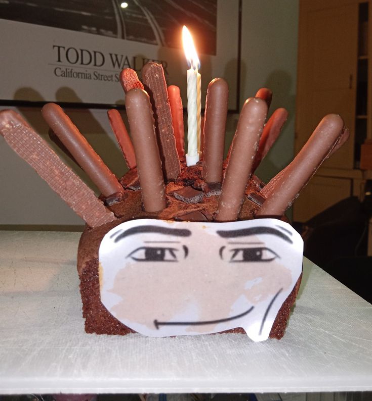 a cake with candles sticking out of it's face on top of a table