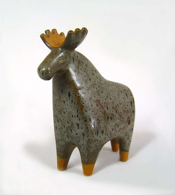 a ceramic moose statue is shown against a white background