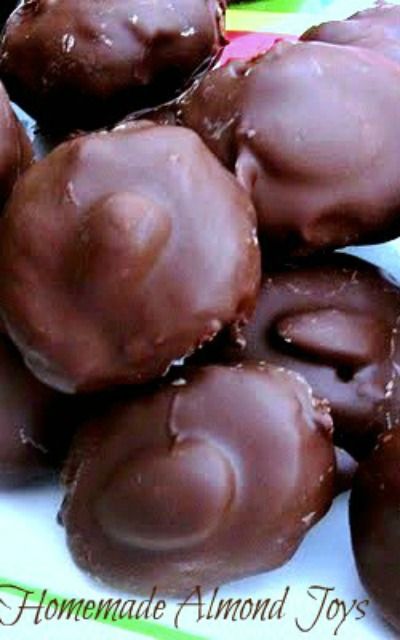 chocolate covered doughnuts sitting on top of each other in front of a green and white sign