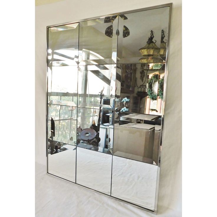 a large mirrored wall mounted cabinet in a room