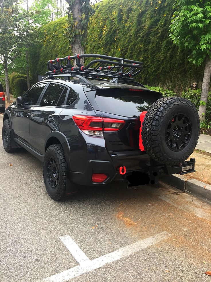 a black car is parked on the side of the road with its skis strapped to it's roof