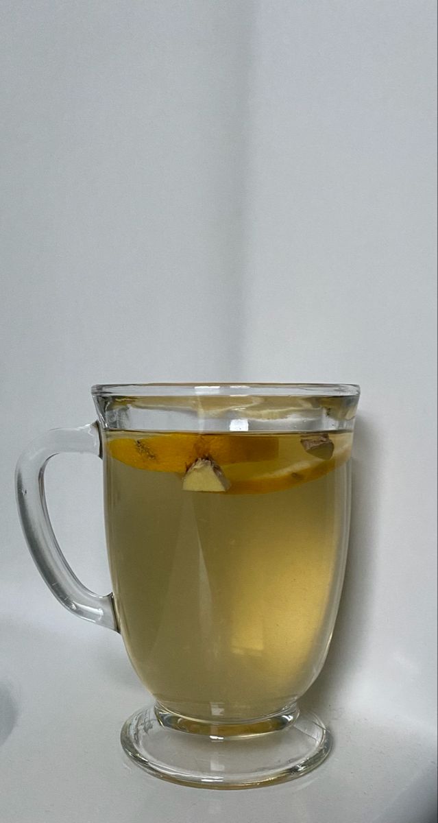 a glass cup filled with liquid on top of a white table