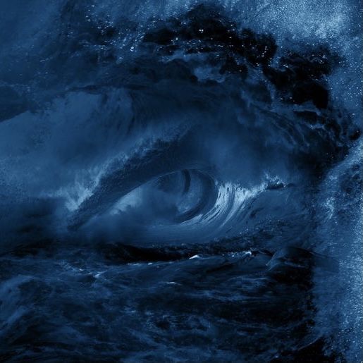 an eye is seen in the middle of a large ocean wave as it breaks through the water