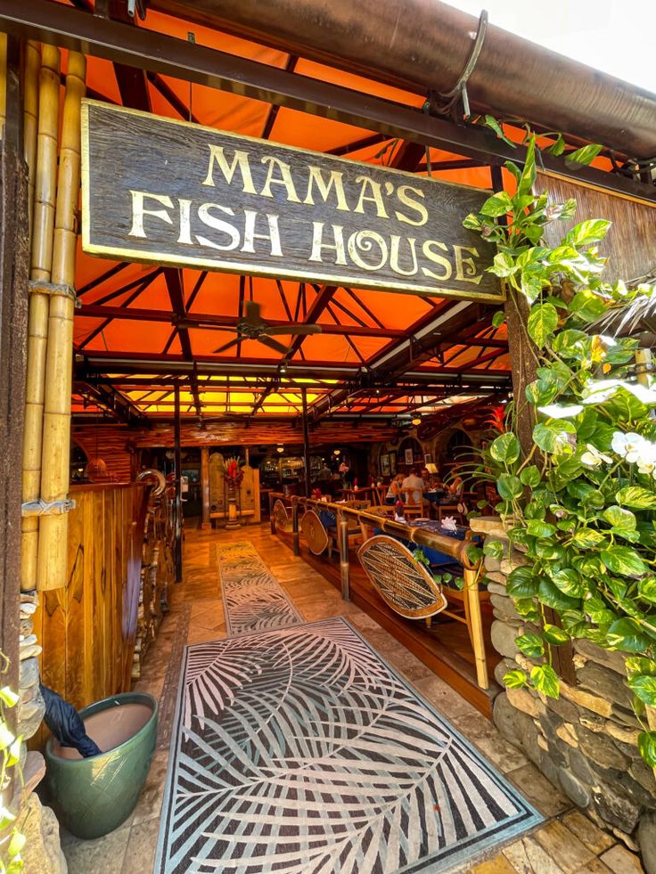 the entrance to mamma's fish house is decorated with tropical plants and bamboo