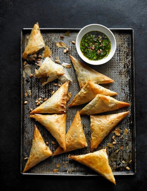 baked pastries on a baking sheet with dipping sauce