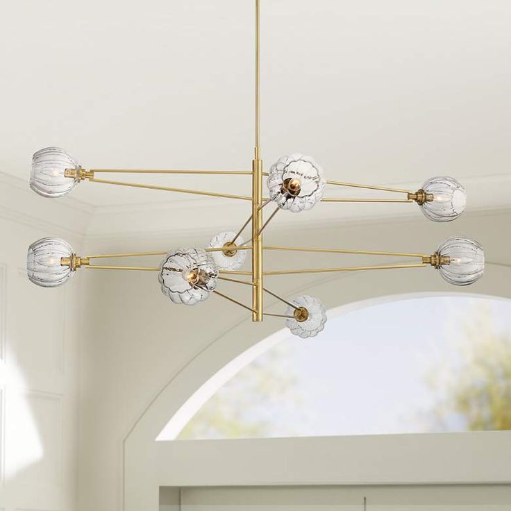 a chandelier hanging from the ceiling in a room with white walls and doors