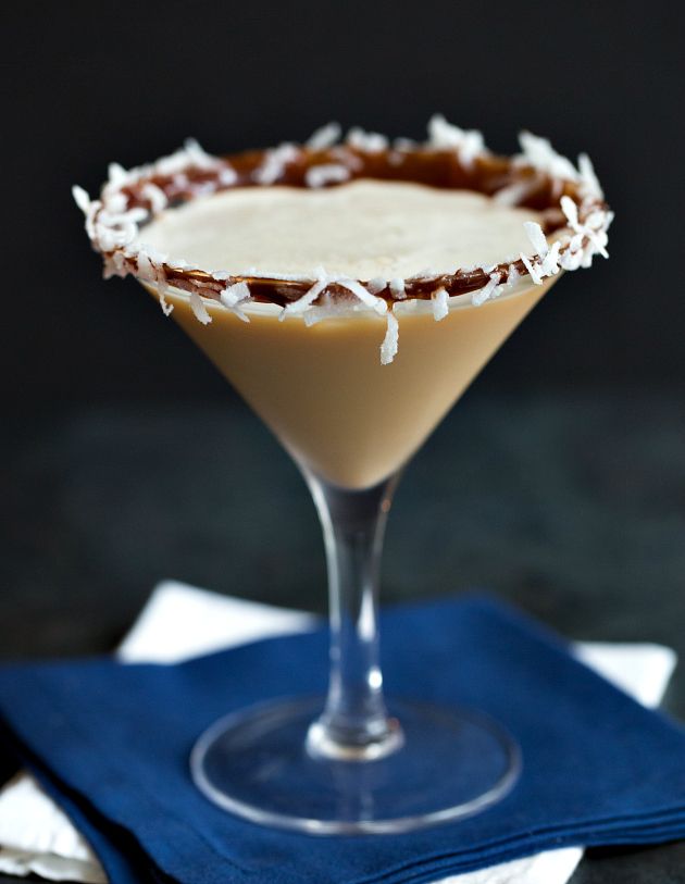 a chocolate martini is garnished with white crumbs on a blue napkin