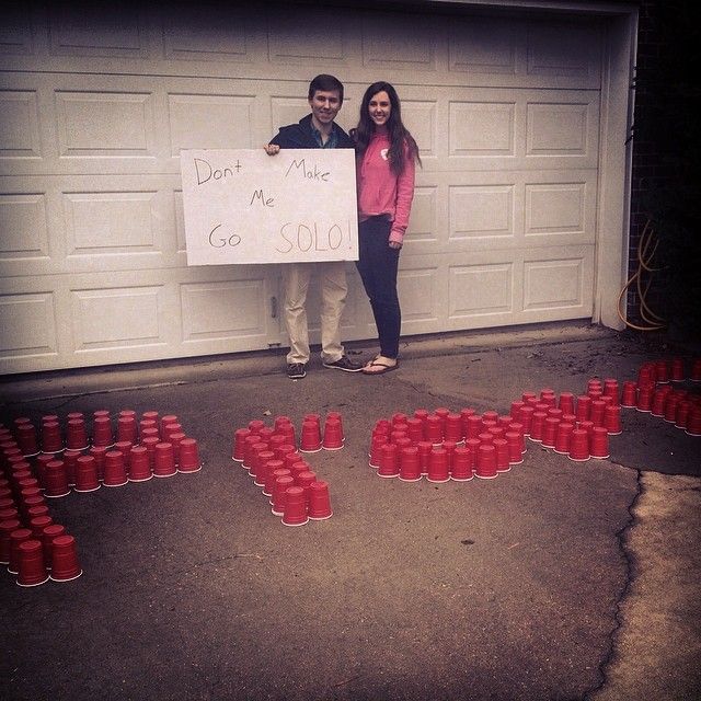 two people standing in front of a garage holding a sign