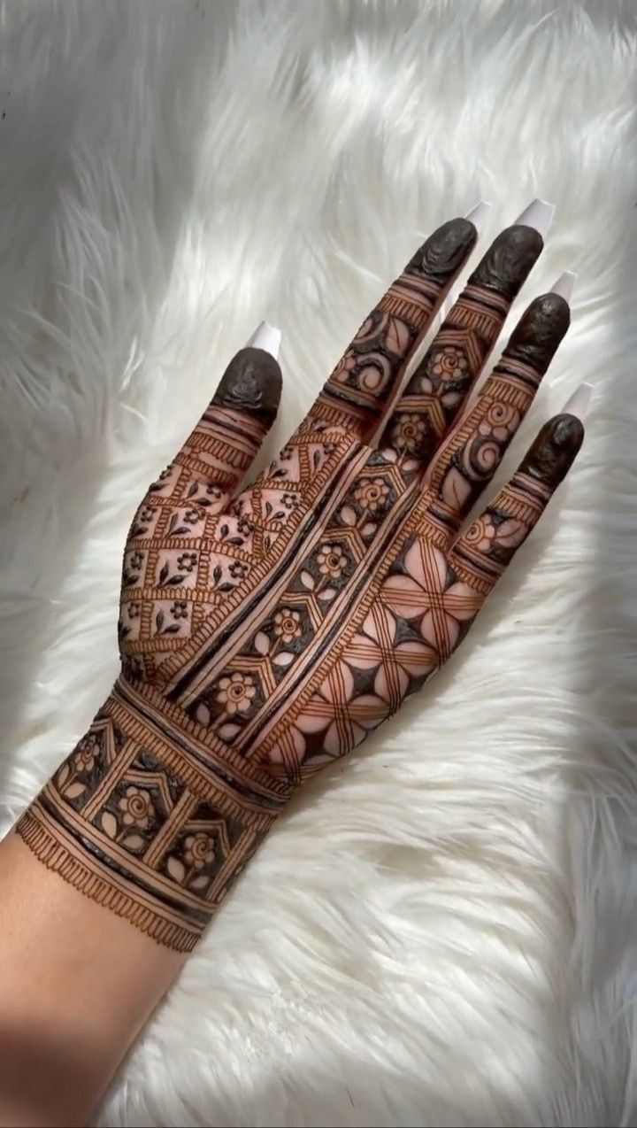 a woman's hand is decorated with hennap and intricate designs on it