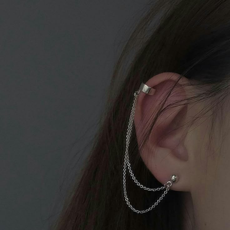 a close up of a person with ear piercings on their ears and behind them is a black background