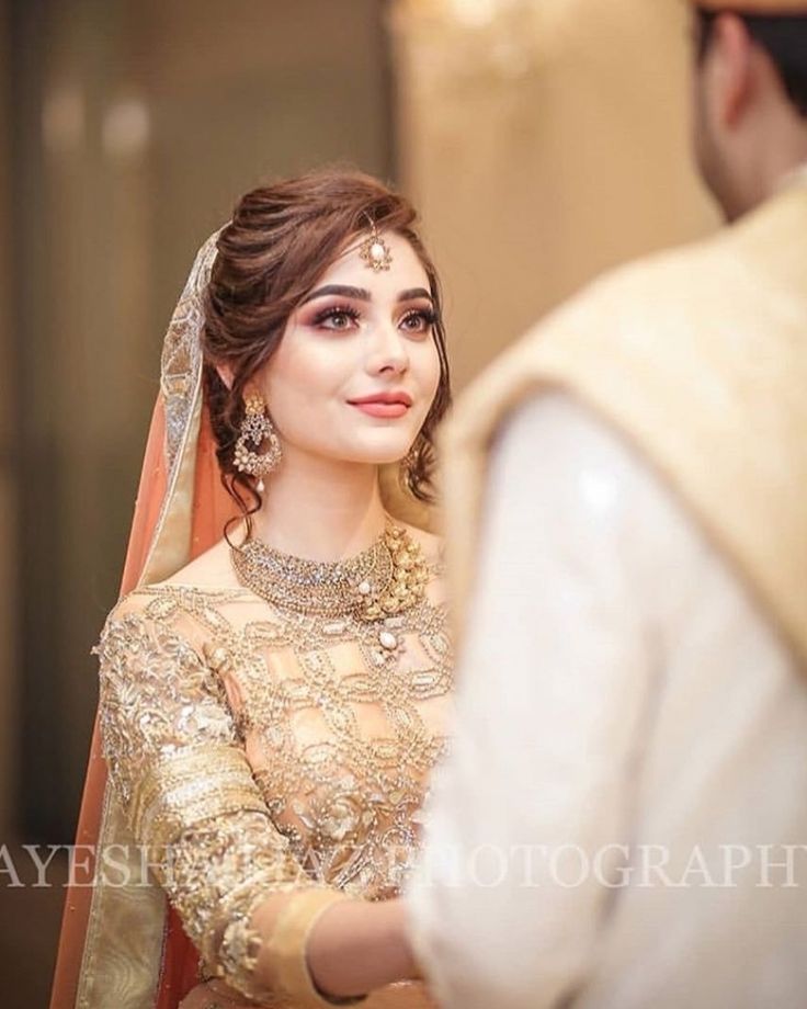 a woman in a bridal gown looking at the groom