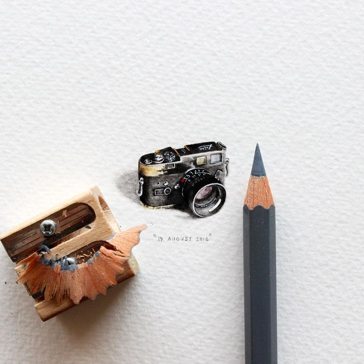 an old camera, pencil and sharpener on paper