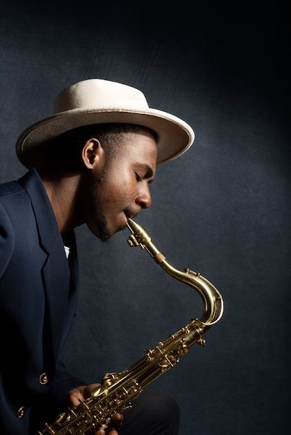 a man in a hat is playing the saxophone