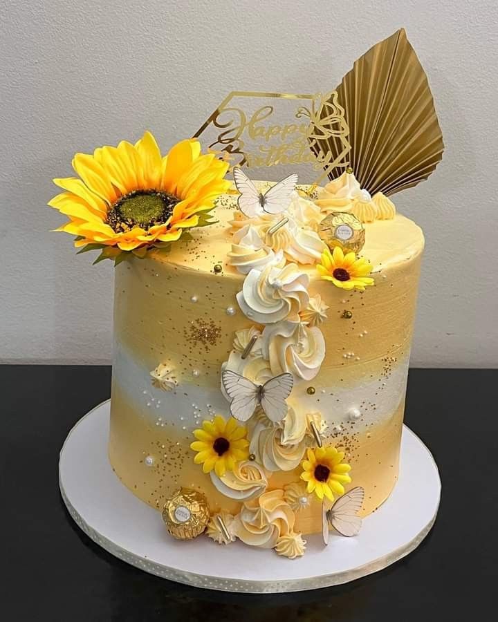 a yellow and white cake with sunflowers on top