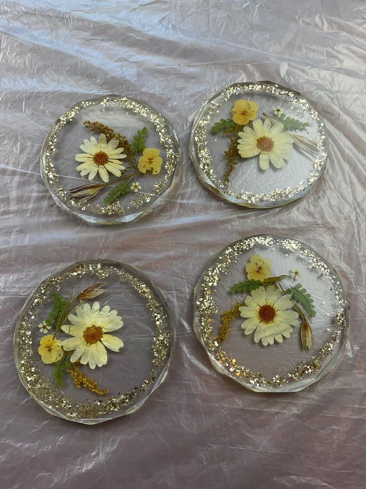 four glass plates with yellow and white flowers on them