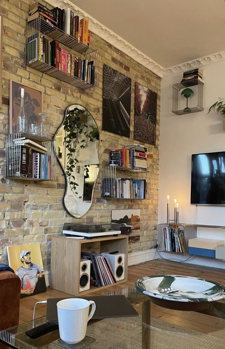 a living room filled with furniture and a flat screen tv mounted on a wall next to a book shelf