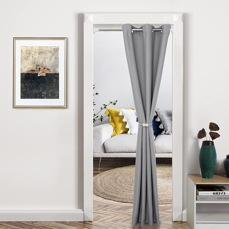 a living room with a white couch and grey curtains