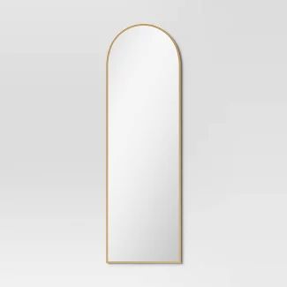 an arched mirror on a white wall