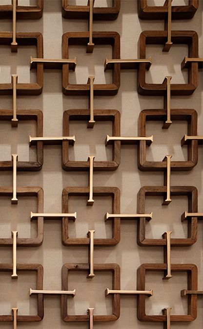 a wall sculpture made out of wood sticks and wooden pegs in the shape of rectangles