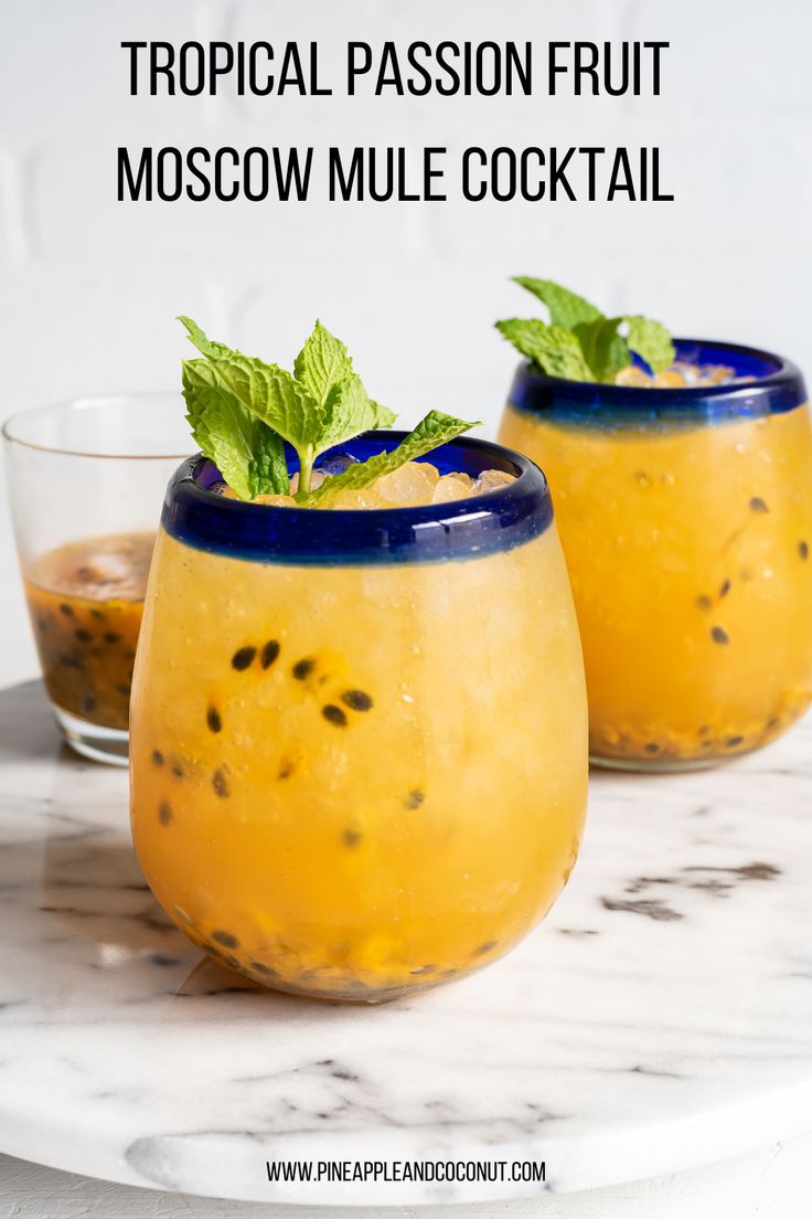 two glasses filled with drinks sitting on top of a marble table