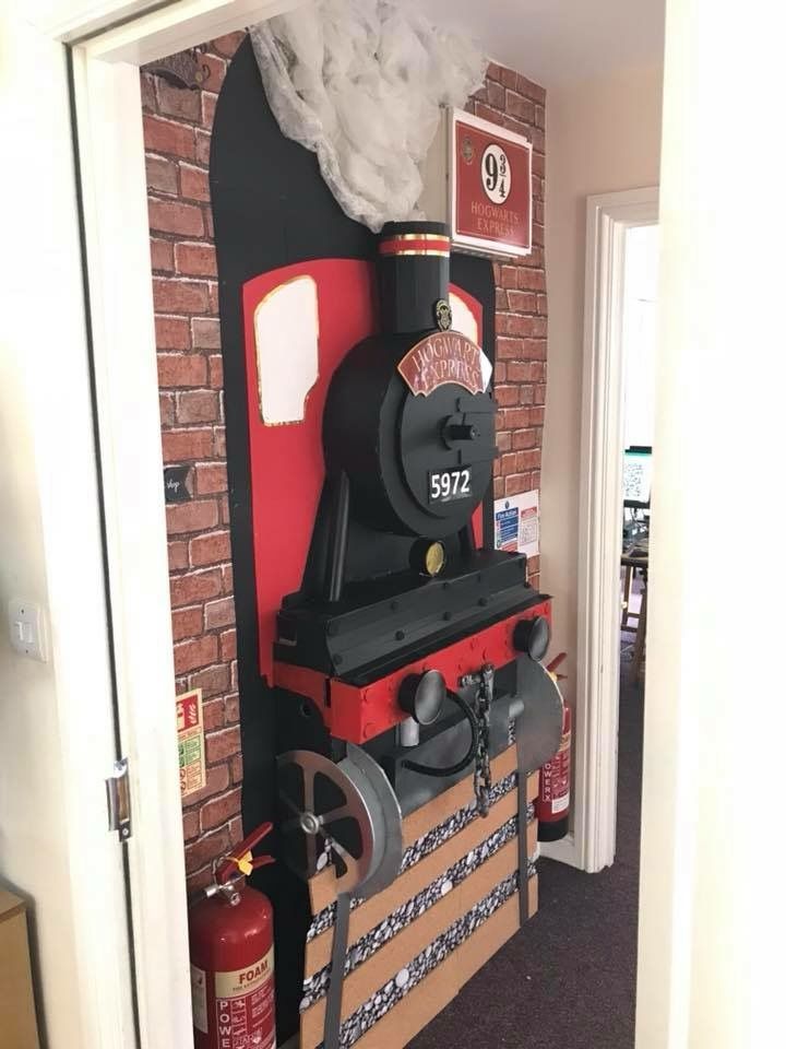 a red and black train is on display in the entry way to a home office