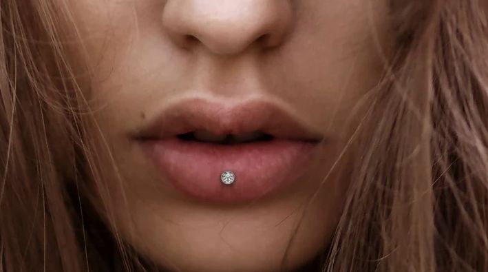 a close up of a woman's face with a nose piercing