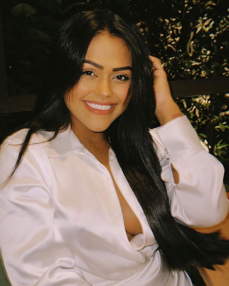 a woman sitting at a table with long black hair