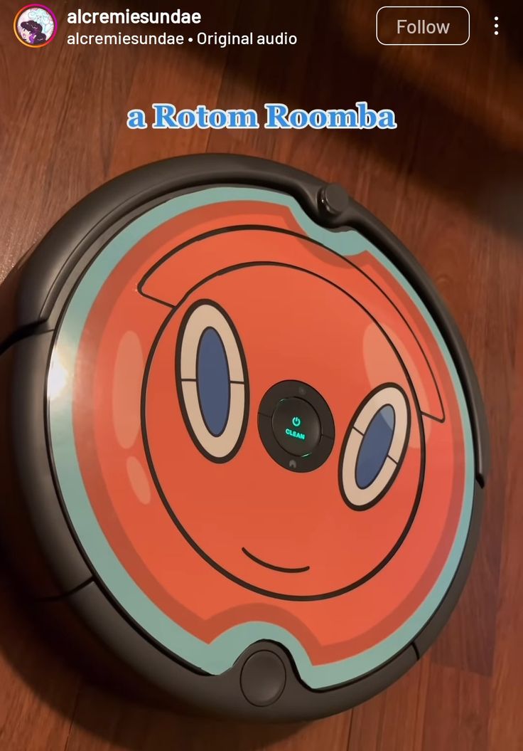 an orange and blue robot is sitting on the floor with its eyes wide open, looking like it's smiling