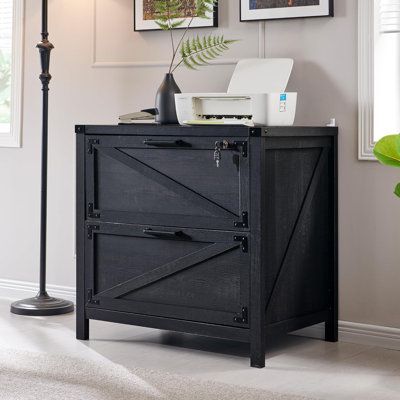 a black cabinet sitting in the corner of a room next to a lamp and pictures on the wall