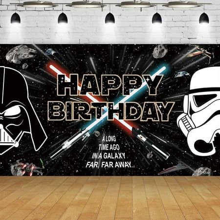 a darth vader and stormtrooper birthday banner on a wooden floor in front of a brick wall