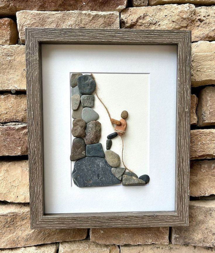 a rock and stone artwork in a wooden frame