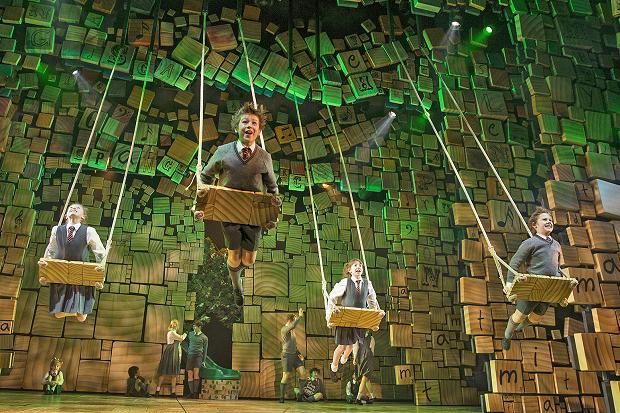 the cast of matilda on stage with their swings