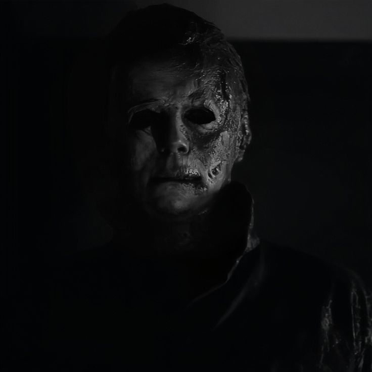 a creepy man in the dark wearing a mask