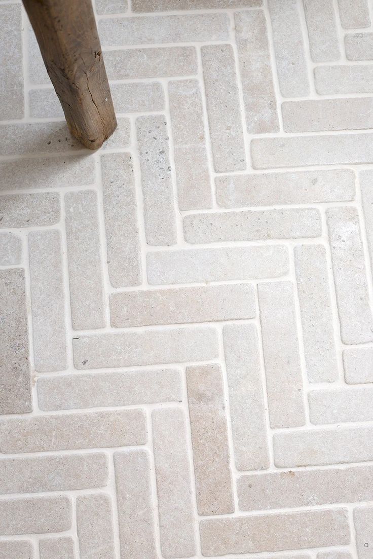 a wooden bench sitting on top of a white tiled floor