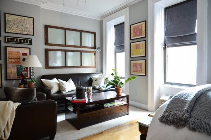 a living room filled with furniture and pictures hanging on the wall above it's windows