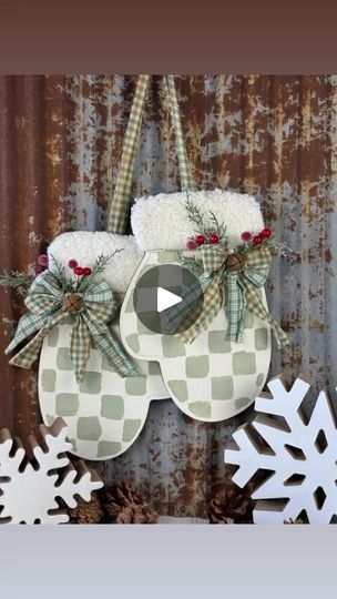 two snowflakes hanging from the side of a metal wall next to christmas decorations