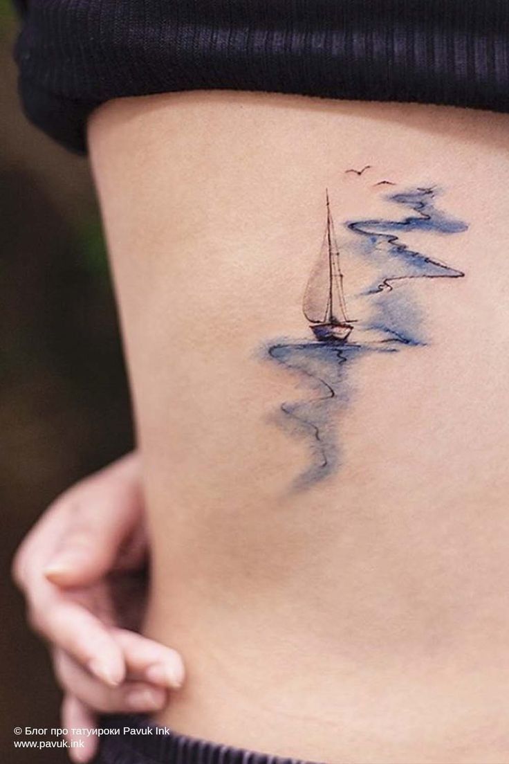 a woman's stomach with a sailboat tattoo on it