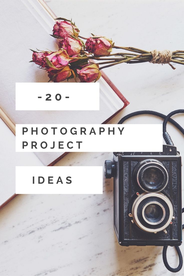 an old camera sitting on top of a table next to a book and some flowers