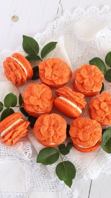 orange frosted cupcakes on a white doily with green leaves