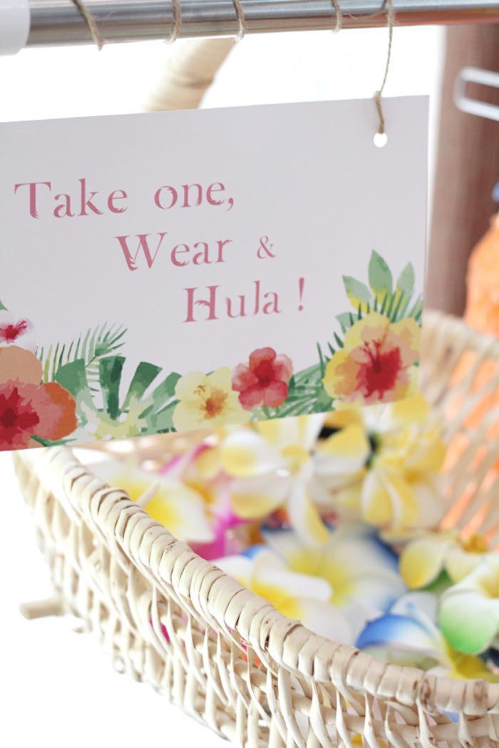 a basket filled with flowers next to a sign that says take one, wear & hula