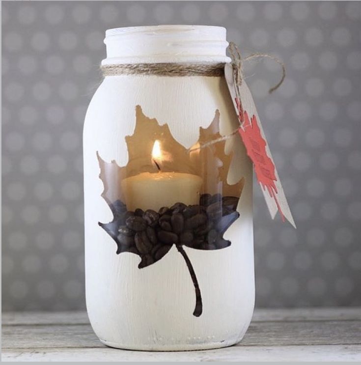 a glass jar filled with coffee beans and a lit candle