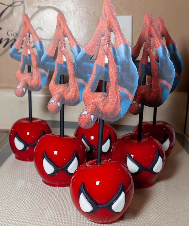 apples with spiderman decorations on them sitting on a table