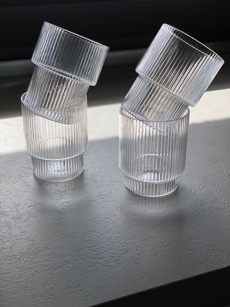 two clear glass cups sitting on top of a table